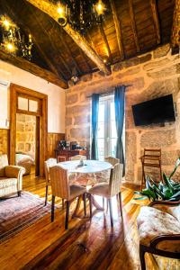 Un comedor con mesa y sillas y un televisor. en Refúgio Rústico - Exclusivo, en Favaios