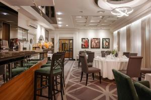a restaurant with a table and chairs and a bar at Hotel Falko in Rumia