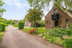 Cozy No 2 Wellness Villa Hottub, Sauna en houtkachel في Hernen: طريق فارغ امام بيت من الطوب