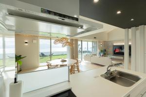 una cucina con un lavello e un tavolo di Hale Moana a Itoshima