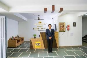 a man in a suit standing at a podium in a lobby at FabHotel New Silver Crown in New Delhi