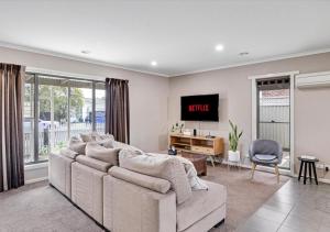 a living room with a large couch and a desk at LUXURY 3-Bed Home Perfect for Families & Groups in Sebastopol