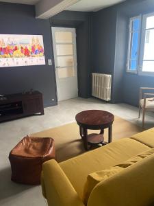 un soggiorno con un divano e un tavolo di Ancienne ferme Gersoise a Riscle