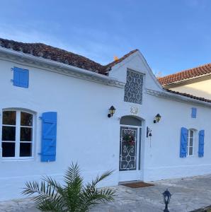una casa bianca con persiane blu e una porta di Ancienne ferme Gersoise a Riscle Altre 65 foto