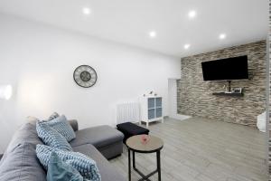 a living room with a couch and a flat screen tv at Guesthouse dos Limites in Espinho