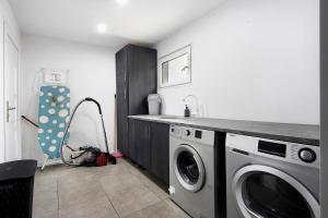 een keuken met een wasmachine en een wastafel bij Guesthouse dos Limites in Ponte de Anta