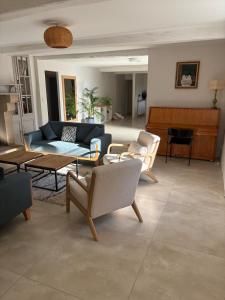 un soggiorno con un divano blu e un pianoforte di Ancienne ferme Gersoise a Riscle