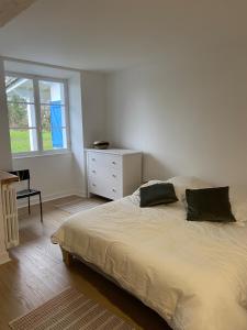 una camera da letto con un letto, un comò e una finestra di Ancienne ferme Gersoise a Riscle