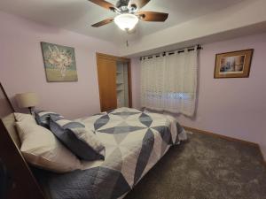 Home away from home في Urbandale: غرفة نوم بها سرير ومروحة سقف