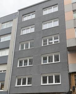 a gray building with white windows at Fogar de Breogan in A Coruña