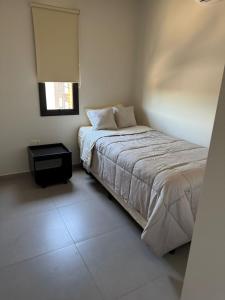 ein weißes Schlafzimmer mit einem Bett und einem Fenster in der Unterkunft Soho 2 Dorm in Luque