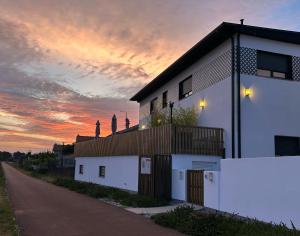 a white building with a sunset in the background at Alma Candida 21 in Valença
