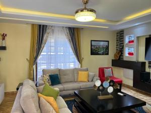 a living room with a couch and a table at Maison Princeton in Kampala