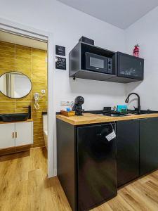 una cocina con fregadero y microondas en Pettit Lion, en Villena 3 fotos más