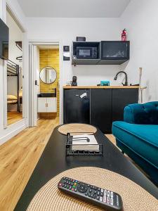 sala de estar con mando a distancia en una mesa en Pettit Lion, en Villena