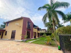カンパラにあるMaison Princetonの私道横のヤシの木のある家