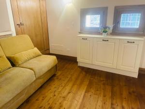 a living room with a couch and a wooden floor at Le 4 Camere in Roverchiara