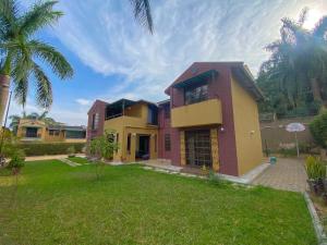 a house with a palm tree in a yard at Maison Princeton in Kampala