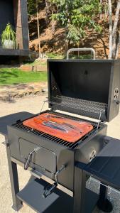 a grill with a red blanket on top of it at Chalé com banheira, piscina e cachoeira privativa in Taubaté