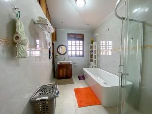 a bathroom with a tub and a shower and a sink at Maison Princeton in Kampala +64 photos
