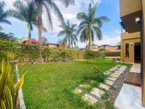 カンパラにあるMaison Princetonのヤシの木と家の庭