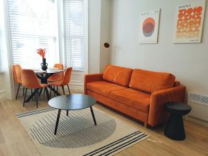 a living room with a couch and a table at Stunning Modern Apartment Sleeps 4 - 6 Min walk from Golden Beaches-Free Parking in Bournemouth