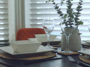a table with two wine glasses and plates on it at Stunning Modern Apartment Sleeps 4 - 6 Min walk from Golden Beaches-Free Parking in Bournemouth +27 photos