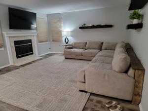 Home away from home في Urbandale: غرفة معيشة مع أريكة ومدفأة