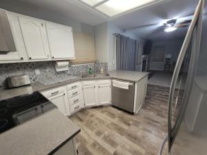 Home away from home في Urbandale: مطبخ بدولاب بيضاء وأرضيات خشبية