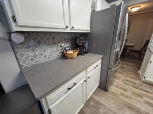 Home away from home في Urbandale: مطبخ مع خزائن بيضاء وثلاجة +13 صورة