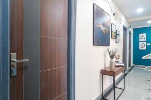 a hallway with a wooden door and a table at FabHotel Broholic Suites - Nr US Consulate, Financial District in Hyderabad