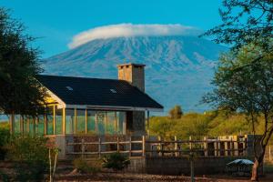 a house with a mountain in the background at Andu Kuboiye Homes in Kimana