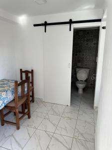 een badkamer met een toilet en een stoel in een kamer bij Bilbao 44 in Santa Clara del Mar +23 foto's