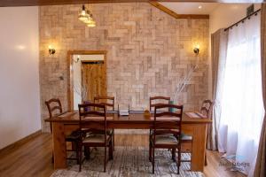 a dining room with a wooden table and chairs at Andu Kuboiye Homes in Kimana