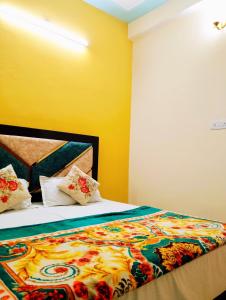 a bedroom with a bed with a colorful blanket at "Om Sadan" Ayodhya Dhaam in Ayodhya