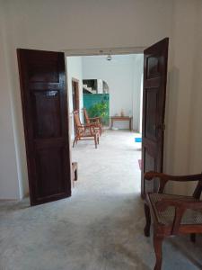 an open door to a living room with chairs at villa Calm Haven in Unawatuna