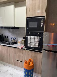 una cocina con estufa y microondas en LEKKI CONSERVATION FURNiSHED APARTMENT 1, en Lagos