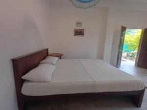 a bedroom with a large bed with white sheets and pillows at villa Calm Haven in Unawatuna
