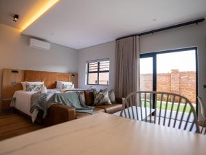 a bedroom with a bed and a couch and a window at The Circle Luxury Self Catering Studios in Potchefstroom