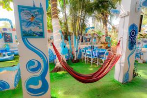 Viik wellness inn -3 Star Resort in Arambol Beach في أرامبول: صورتين لأرجوحة في منتجع