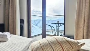 a bedroom with a bed and a view of a mountain at GVC New Gudauri Loft-2 in Gudauri