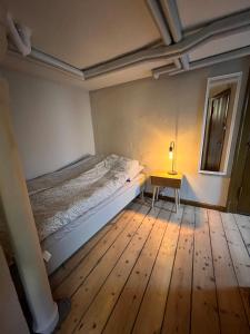 een slaapkamer met een bed en een lamp op een tafel bij The Cozy Cave Odense Center in Odense