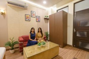 Dos mujeres están sentadas en una sala de espera. en FabHotel Z Heart, en Tughlakābād