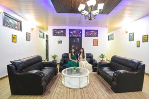 Dos mujeres sentadas en una sala de espera con muebles de cuero. en FabHotel Z Heart, en Tughlakābād