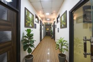 Un pasillo de una oficina con plantas en macetas. en FabHotel Z Heart, en Tughlakābād
