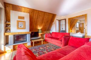 a living room with red furniture and a fireplace at Hostdomus - Rooftop Deluxe Suite in Sestriere