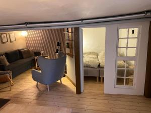 een woonkamer met een bank en een bed bij The Cozy Cave Odense Center in Odense