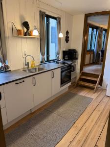 een keuken met een spoelbak en een fornuis bovenste oven bij The Cozy Cave Odense Center in Odense