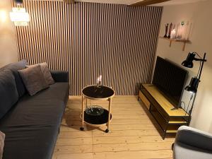 a living room with a couch and a table with a candle at The Cozy Cave Odense Center in Odense