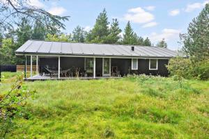 une maison noire avec un porche dans un champ dans l'établissement 891-Snedsted-Grahavrevej-21, à Snedsted